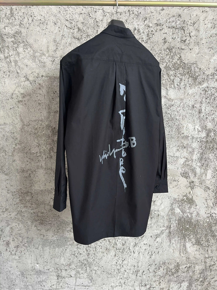 A simple long-sleeved single-breasted shirt with a double-layered collar, solid color and asymmetrical design