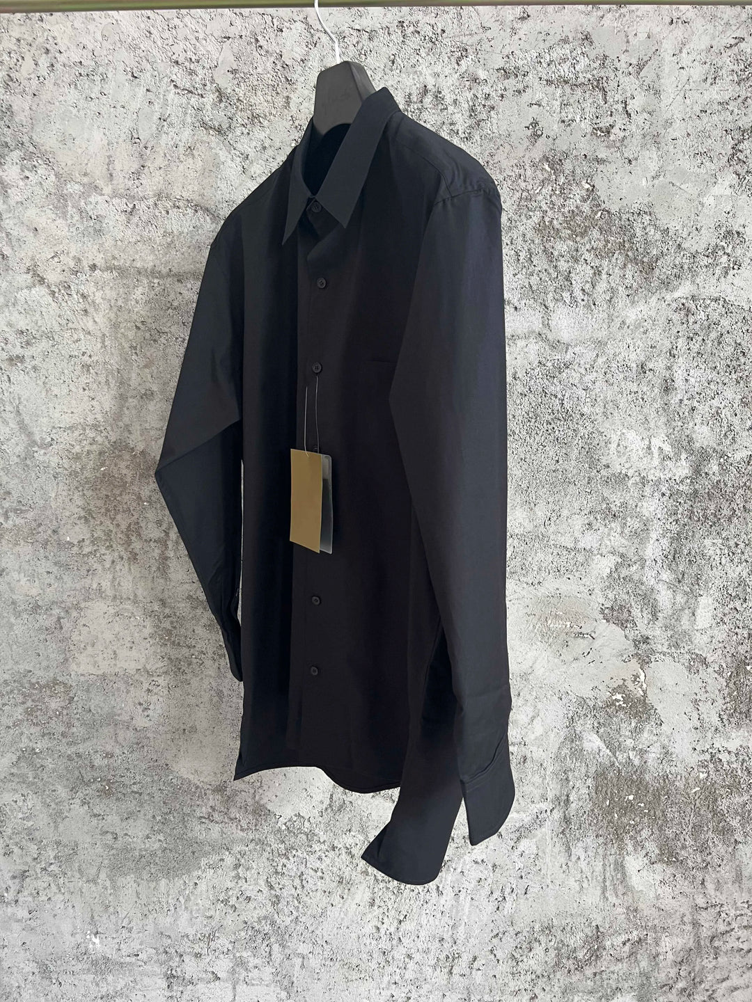 A simple long-sleeved single-breasted shirt with a double-layered collar, solid color and asymmetrical design